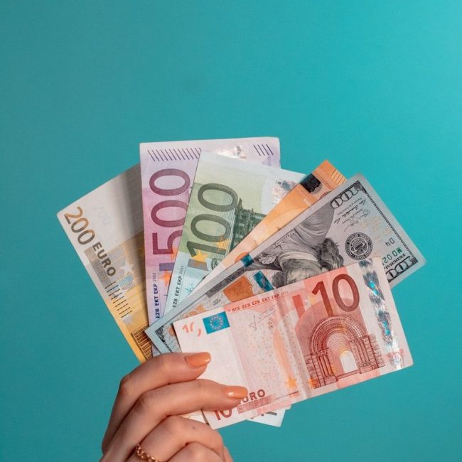 person holding fan of 100 us dollar bill